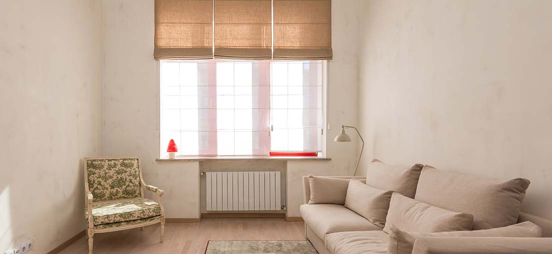 Window dressed in earthy-toned Roman shades for a touch of natural elegance.