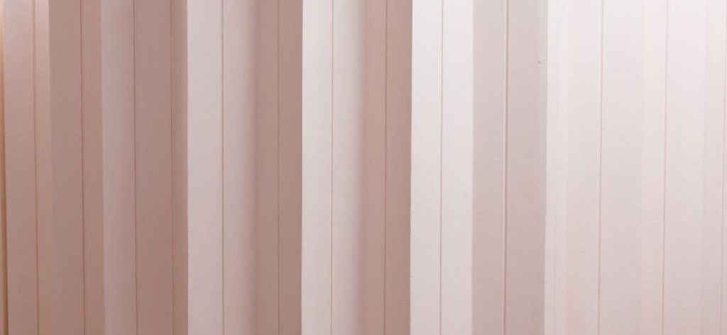 Close-up view of soft pink fabric vertical blinds on a sliding glass door in Simi Valley.