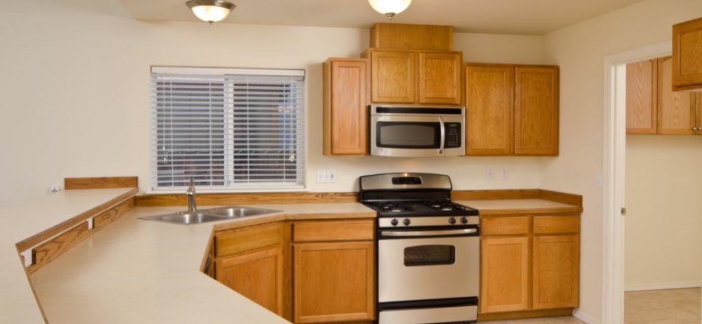 Faux wood blinds tilt upwards to let in fresh air to the kitchen.