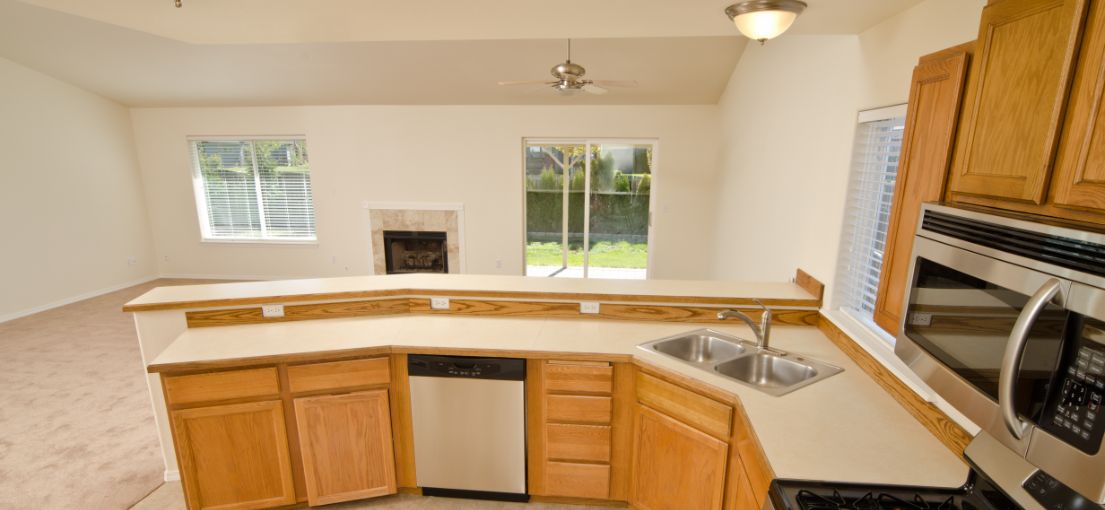 Open kitchen with sleek black faux wood blinds partially raised for sunlight.