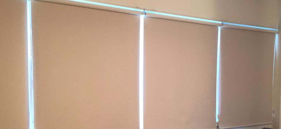 Fabric roller shade in a neutral color, shown in detail.