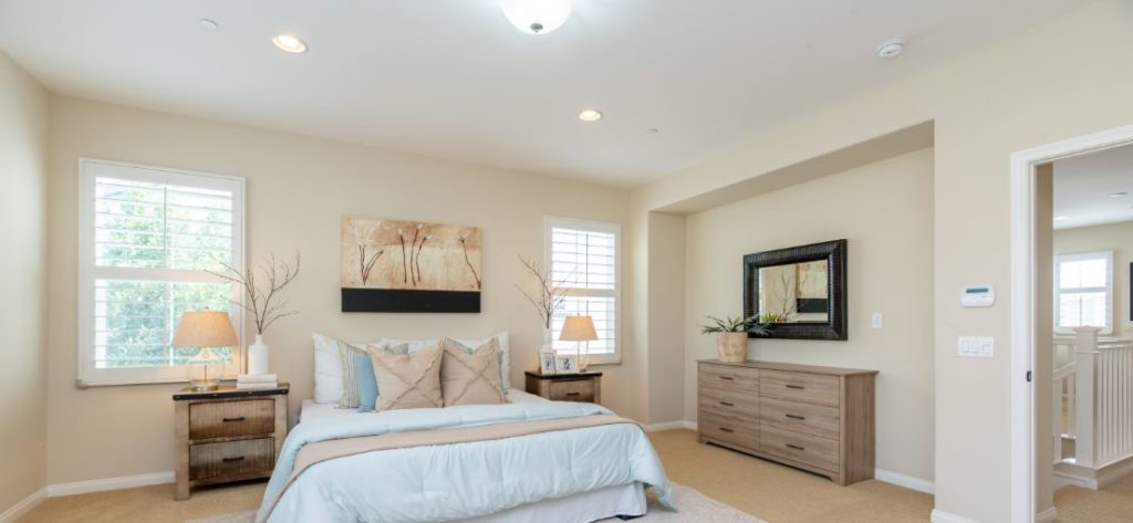 Wood blinds offer natural light control and privacy for a restful night's sleep in an Avocado Heights bedroom.