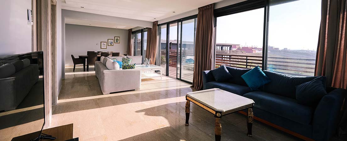 Open living room featuring brown blinds on sliding glass doors.