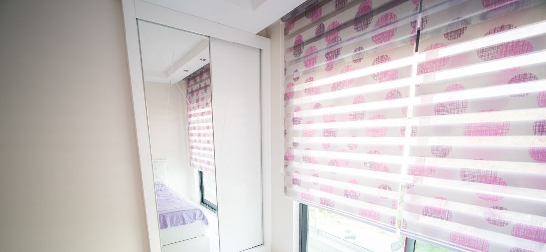 Bedroom with colorful layered window shades