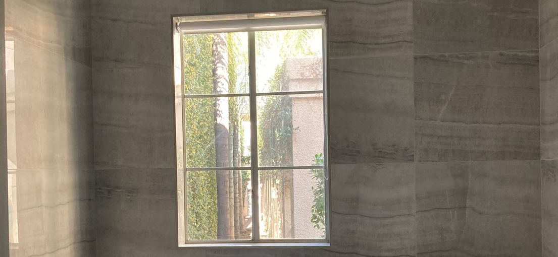 Sheer roller shade casting soft light in an upscale bathroom renovation in Encino.