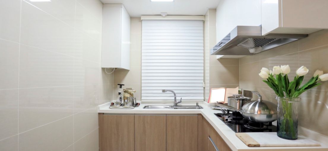 A Santa Clarita kitchen features a window with white layered shades, highlighting the beauty and functionality of this custom window treatment.