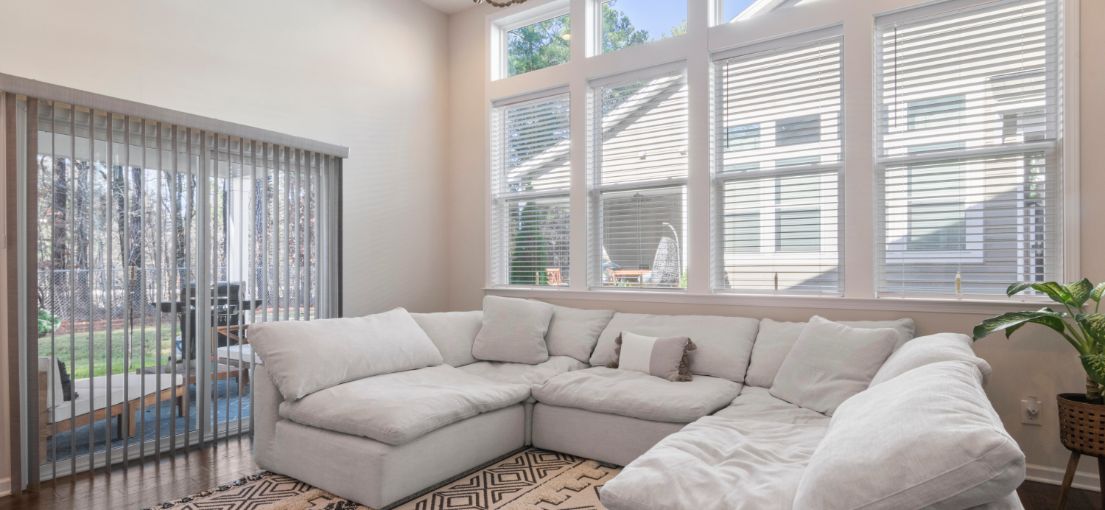 Northridge living room featuring room darkening vinyl blinds and vertical blinds for enhanced privacy and style.