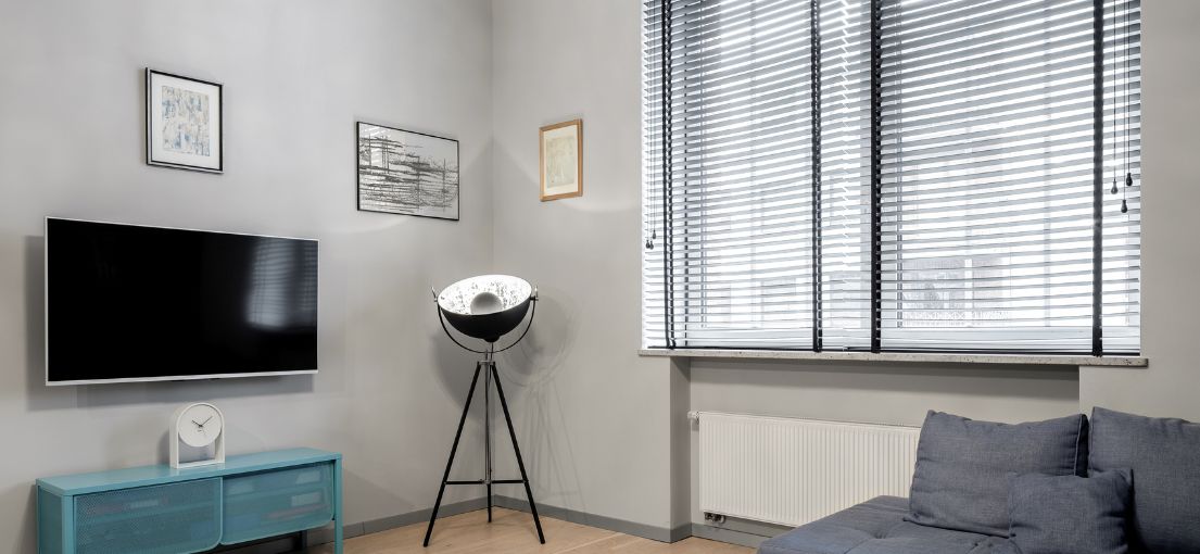 Interior view of a studio's living room with Venetian blinds installed.