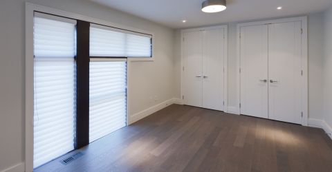 A spacious bedroom featuring custom room darkening vinyl blinds installed by Master Blinds in Burbank.