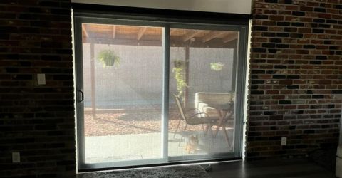 Custom screen roller shades installed on a large patio door in Calabasas living room.