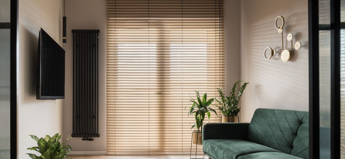 Chic green sofa complemented by Master Blinds' room darkening solutions in a South Pasadena home.