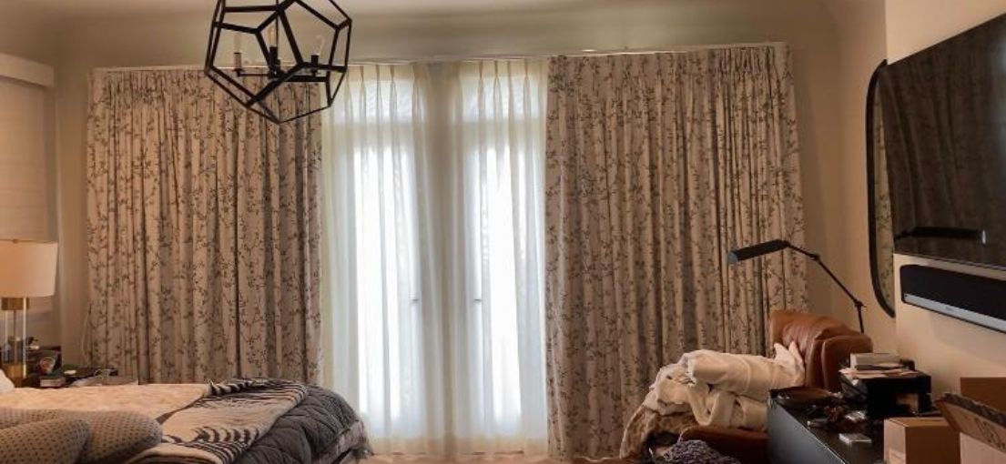 Light-filtering curtains paired with floral printed drapes and Roman shades in a serene Venice bedroom setting.