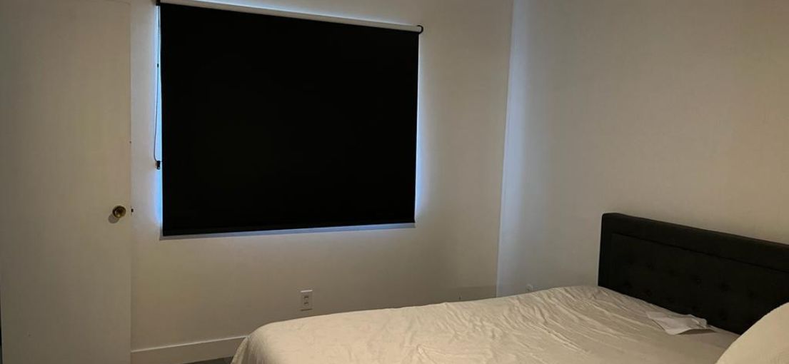 Sleek black roller shades enhancing the contemporary look of a West Hills master bedroom.