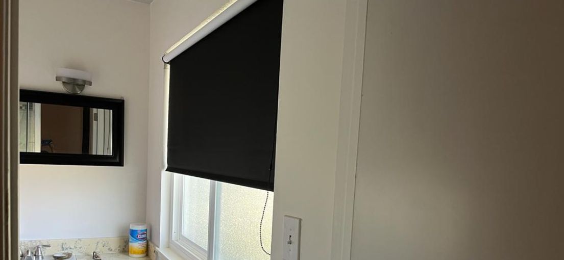 Master Blinds' custom black roller shades in a stylish West Hills bathroom.