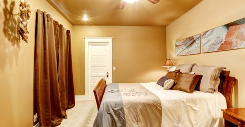 Malibu bedroom with custom blackout drapery, offering full light control and elegant window treatments.