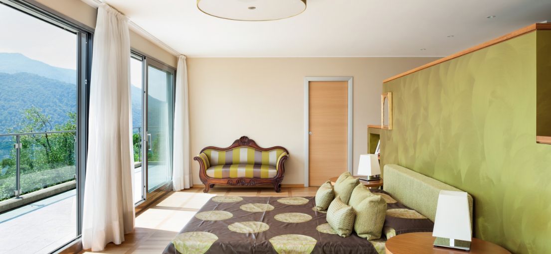 Modern bedroom in Sunland with soft, flowing drapes installed on large windows.