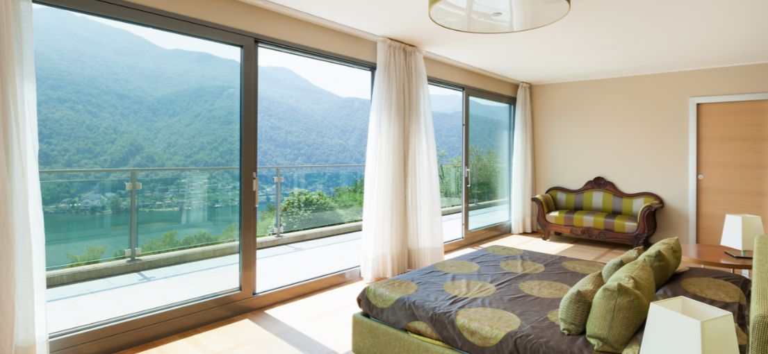 Bright and airy Sunland bedroom with custom light drapery complementing the large windows.