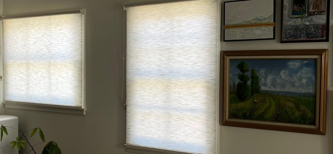 Living room with sheer roller shades fully closed on windows in Sunland home.