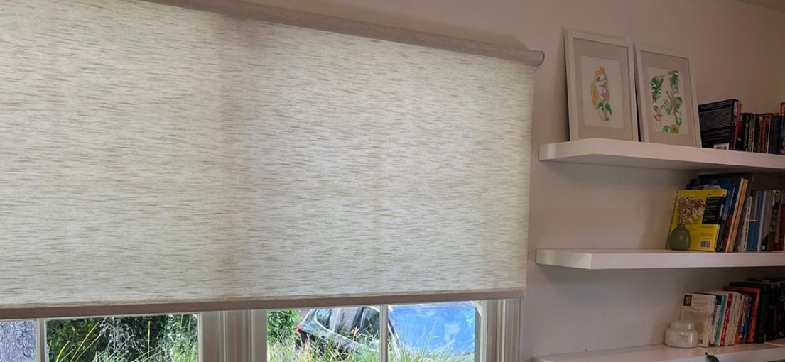 Living room with sheer roller shades partially closed on windows in Sunland home.