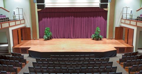 Tarzana High School event hall stage with custom heavy plush drapery installed for elegant ambiance.