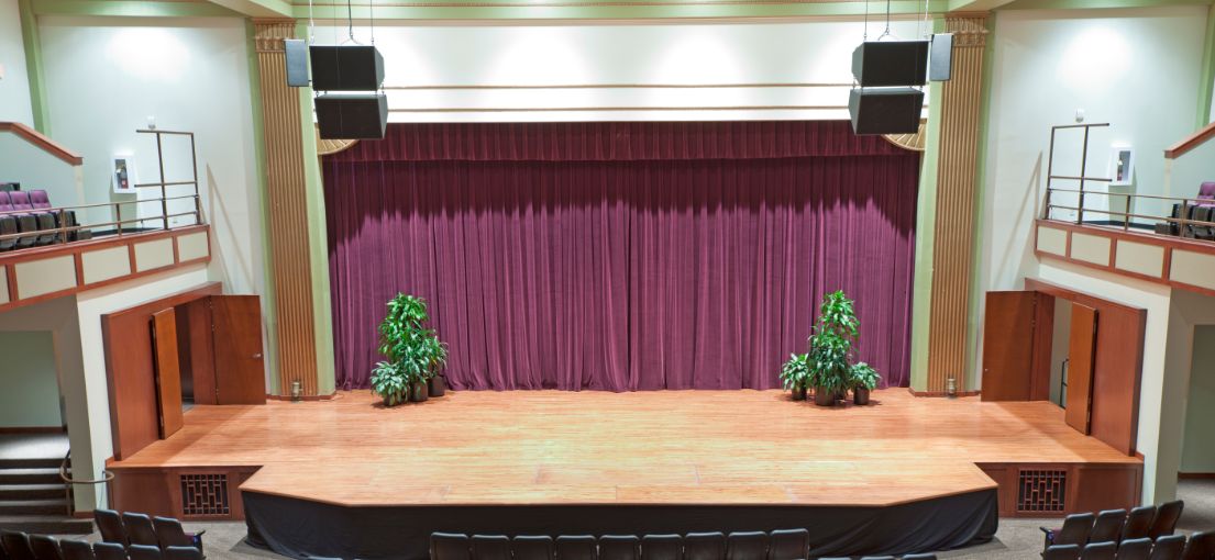 Custom stage drapery in deep plush fabric designed for Tarzana High School event hall.