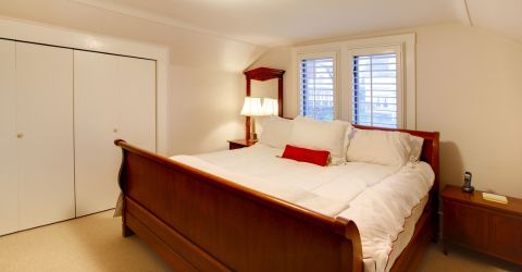 Cozy bedroom in Santa Monica with plantation shutters on windows, providing light control and privacy.