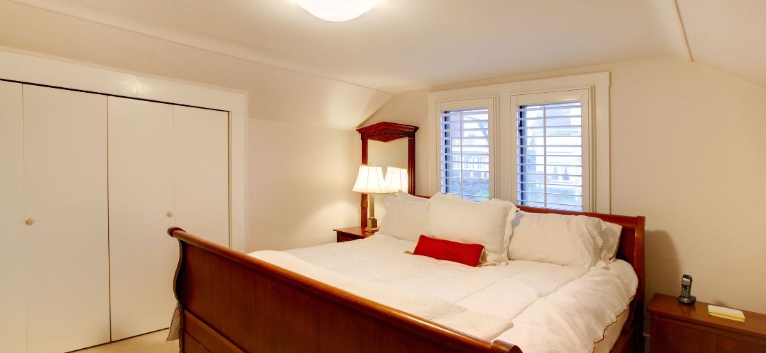 Master Blinds plantation shutters in a Santa Monica bedroom, adding a cozy ambiance and functional light control.