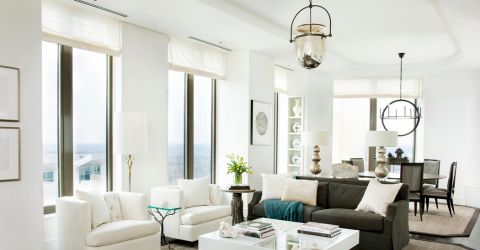 Modern condo living room featuring custom white Roman shades on large windows.