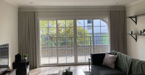 Bright Sherman Oaks living room featuring custom curtains by Master Blinds, providing a light and airy atmosphere.