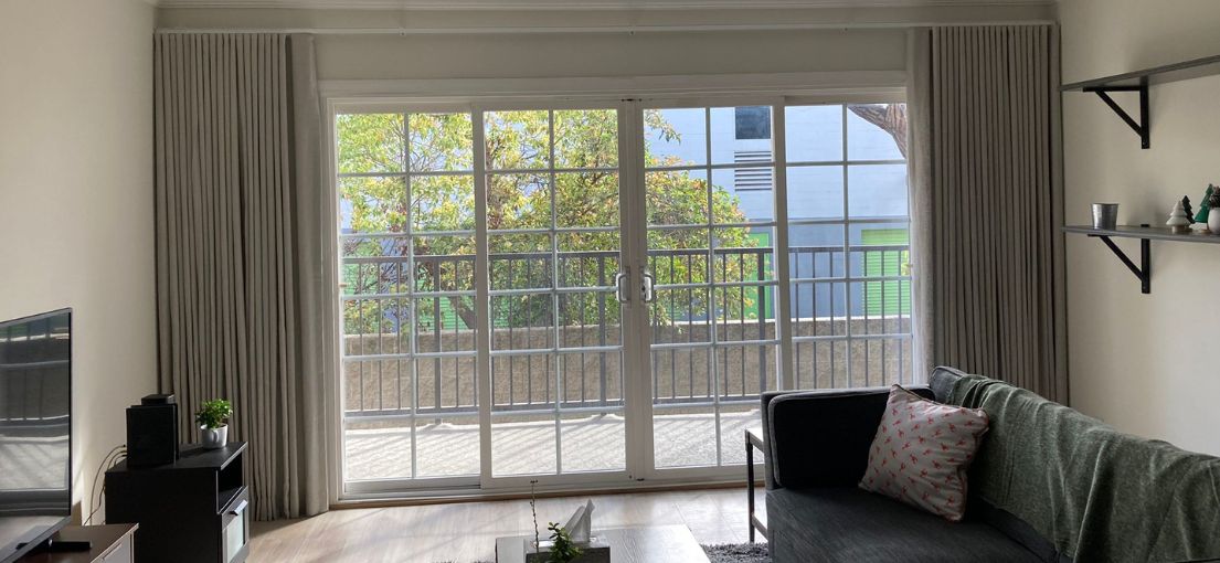 Sherman Oaks apartment living room with custom curtains installed by Master Blinds, offering both privacy and a beautiful view.