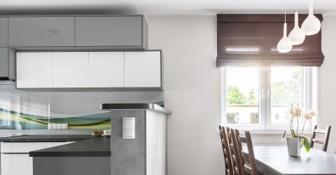 Modern kitchen in Encino featuring custom dark Roman shades for elegant light control.