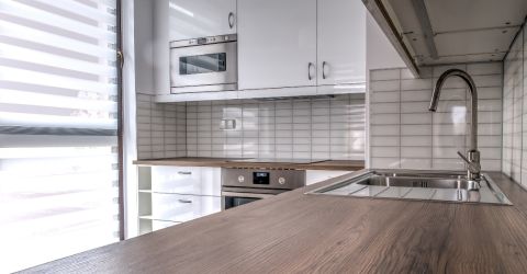 Sleek modern kitchen in Sunland featuring layered shades filtering natural light.